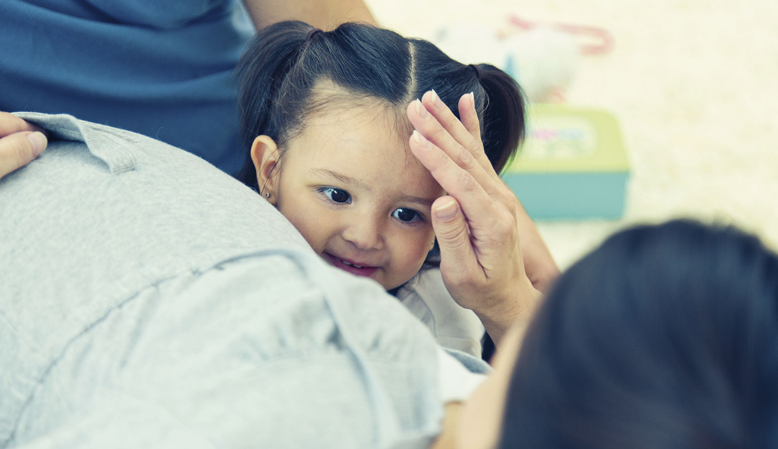 Mutter streichelt ihrer Tochter über den Kopf. 