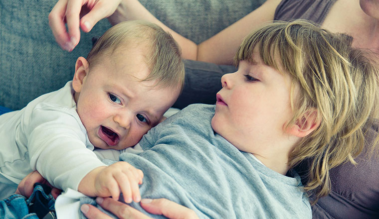 Kind und Baby auf dem Sofa.