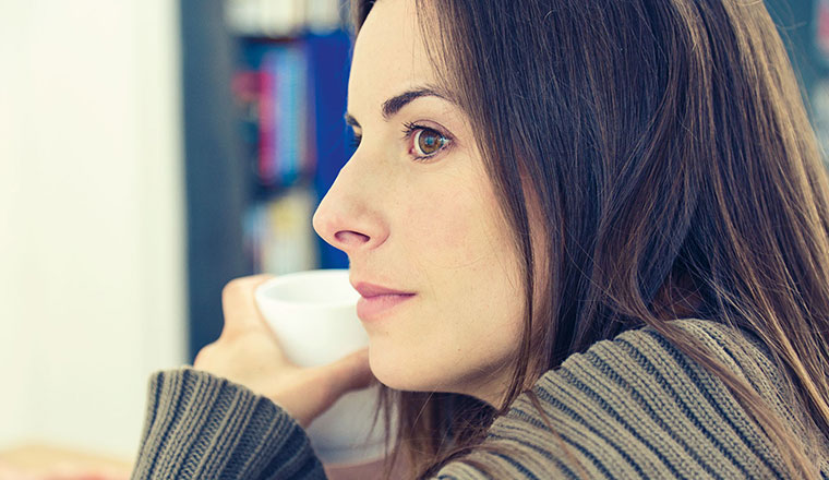 Nachdenkliche Frau mit Kaffeetasse.