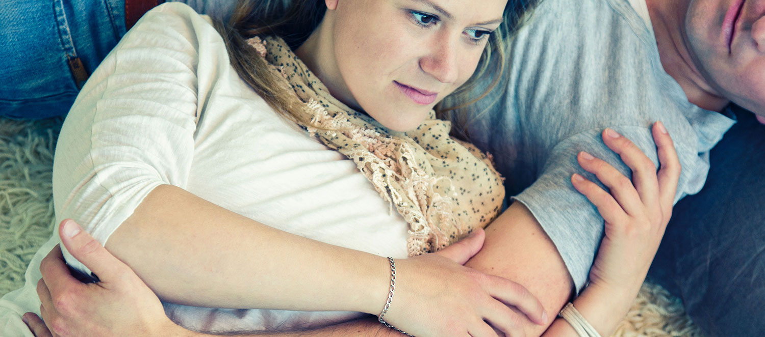 Frau nachdenklich im Arm vom Partner