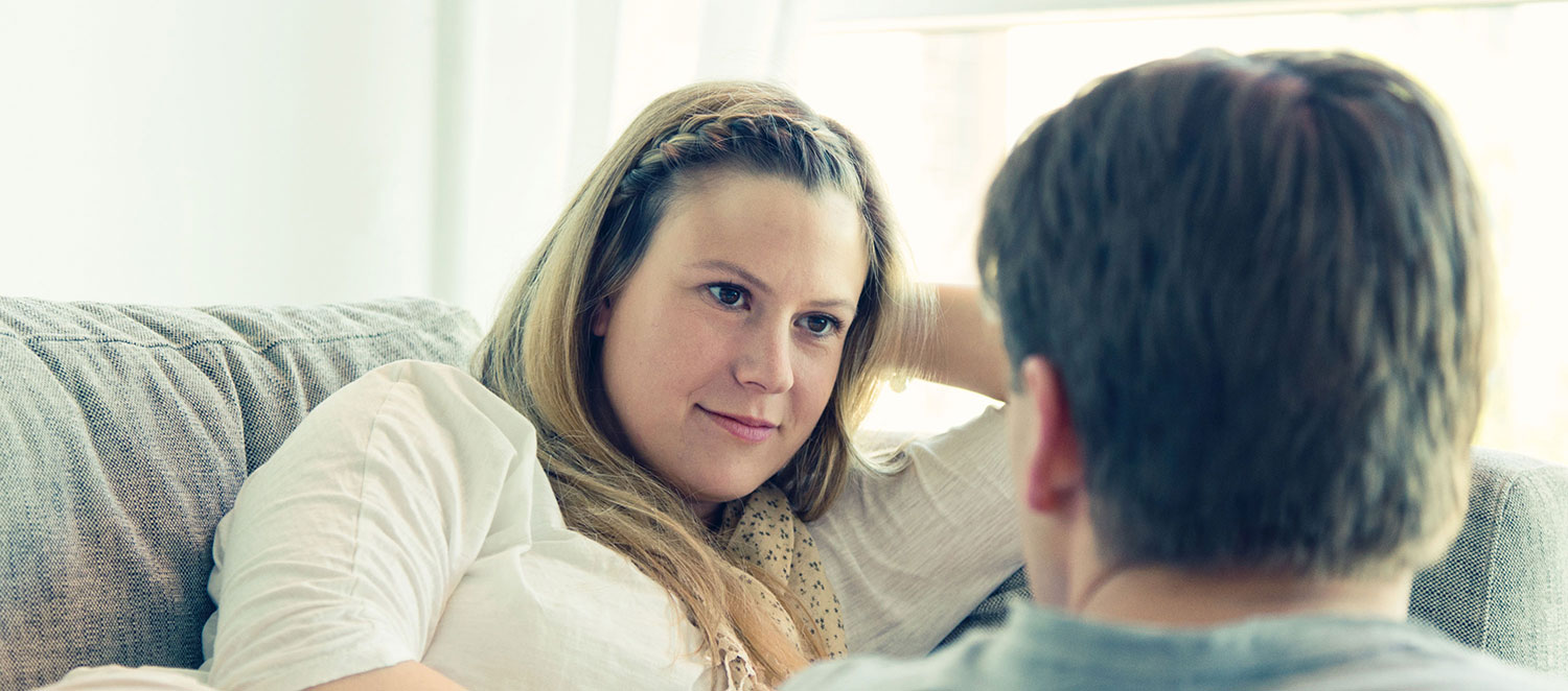 Junge Frau schaut zuversichtlich zu ihrem Partner. 