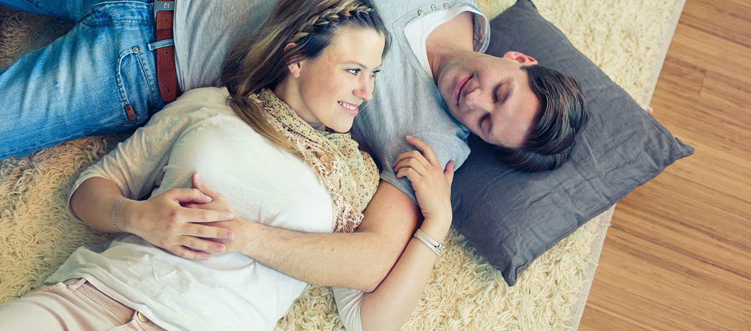 Glückliches Paar liegt auf einem Teppich