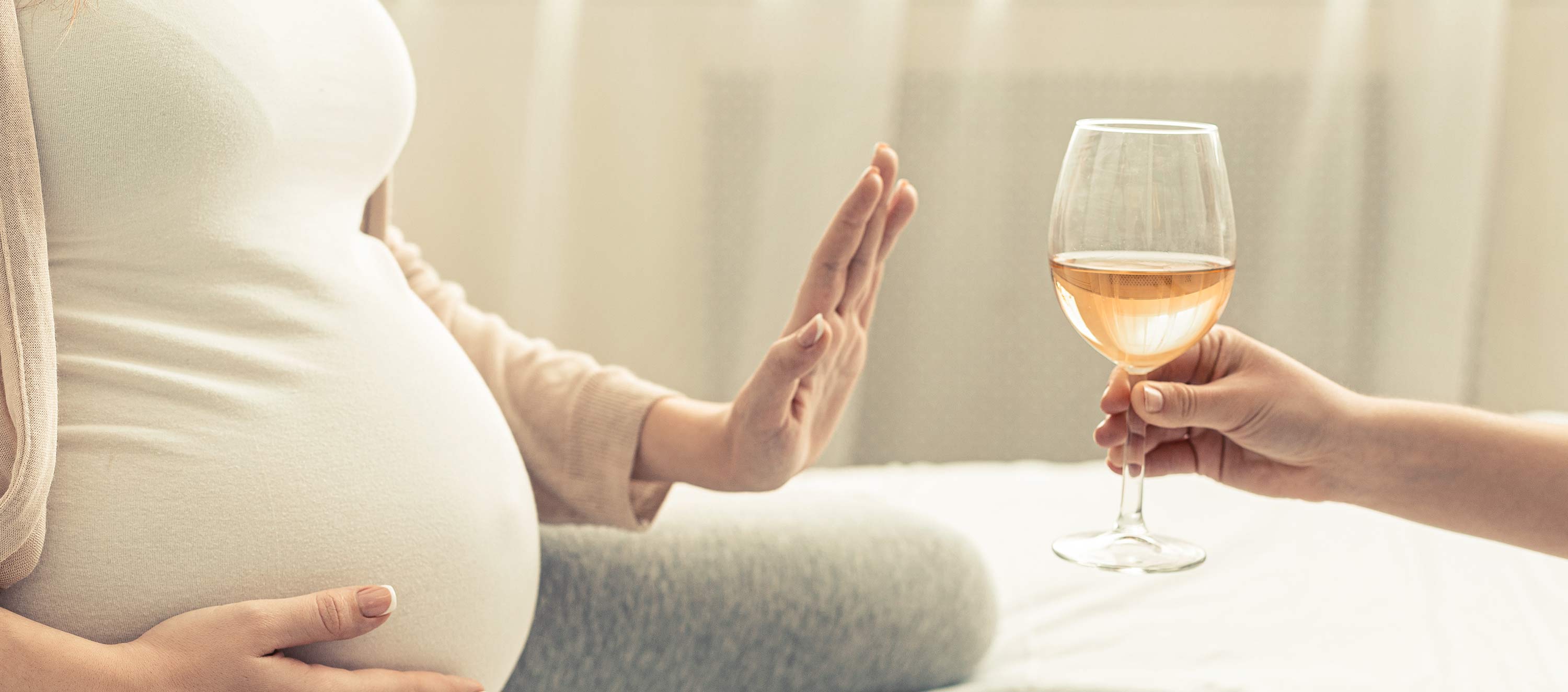 Schwangere Frau lehnt Glas Wein ab. 