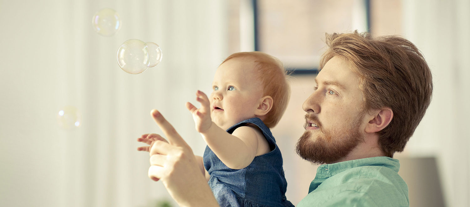 Vater mit Kleinkind und Seifenblasen