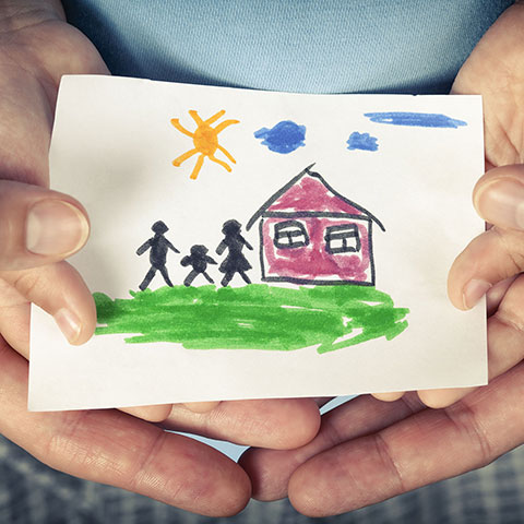 Vater und Kind halten Zeichnung von Haus und Familie in den Händen. 