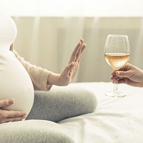 Schwangere Frau verweigert ein Glas Wein. 