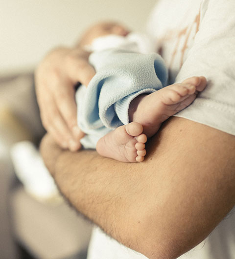 Vater mit einem Baby auf dem Arm. 