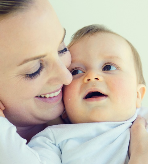 Mutter und Baby lächeln sich an